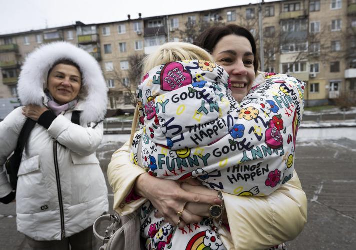 Yana Malyk hugs her friend Halyna Ladyga, facing camera, outside a government hub in Dnipro, Ukraine, Dec. 11, 2023 after seeing her for the first time since leaving Ukraine in 2022. The two were good friends living in Svatove, Luhansk region, before the war. Ladyga relocated to Dnipro with her family.