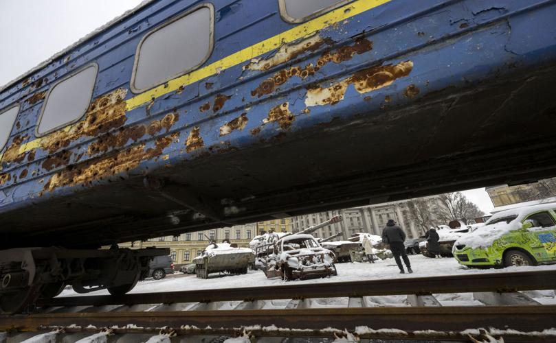 A bombed railroad car that was destroyed by an Russian attack on March 5, 2022, frames an exhibit of destroyed Russian military equipment on in St. Michael’s (Mykhailivska) Square in Kyiv, Ukraine. The empty train was traveling from Kyiv to Irpin to take refugees to safety.
