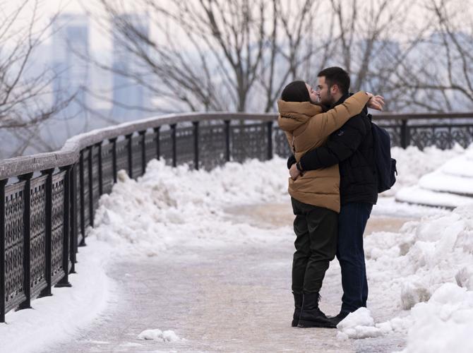 Mariia Vynnychenko, left, and Olekander Bydantser kiss above the Dnipro River in the Volodymyrska Hirki Park Friday, Dec. 15, 2023, in Kyiv, Ukraine. (The Gazette, Christian Murdock)